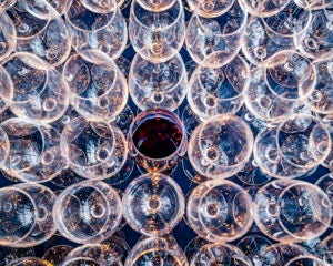 Rows of glasses, one with red wine